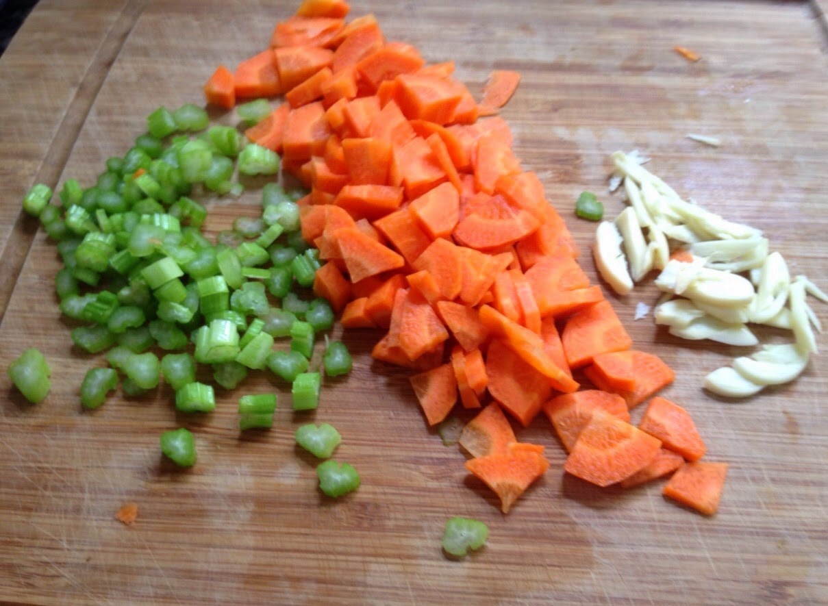 Legumes frescos sobre tábua de madeira, em tons de verde, laranja e branco, clima caseiro e natural.